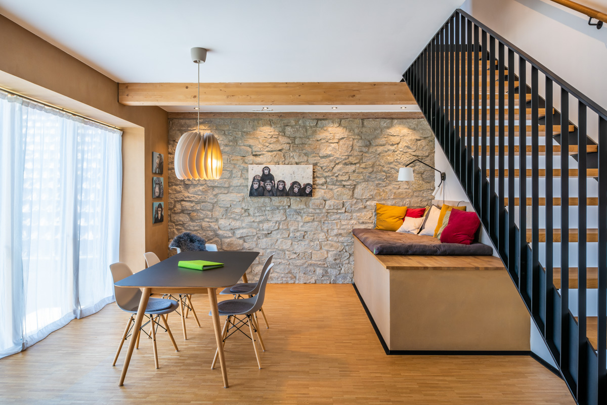 Wohnbereich Natursteinwand und Treppe in Ferienwohnung